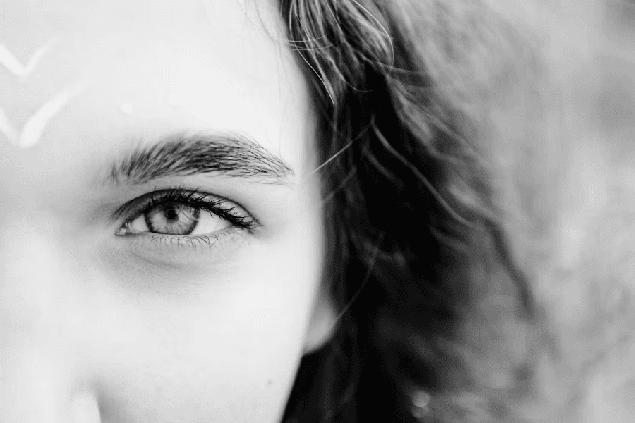 Primer plano en blanco y negro de una ceja bien definida y un ojo